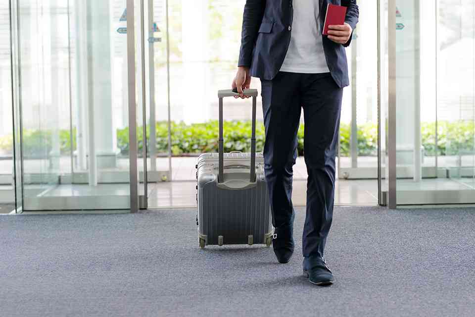 Mann mit Koffer am Flughafen